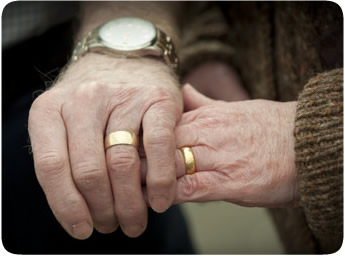 Close up view showing joined hands of elderly couple