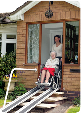 Eldery lady leaving her house in a wheelchair