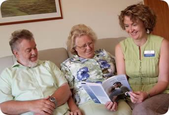 A stroke nurse working with a patient and carer in their home